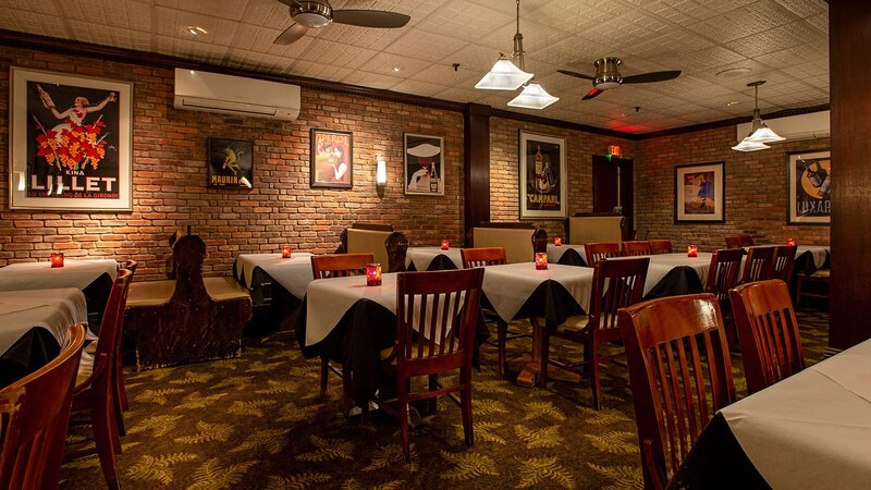 View of entire dining room with many set tables and booths