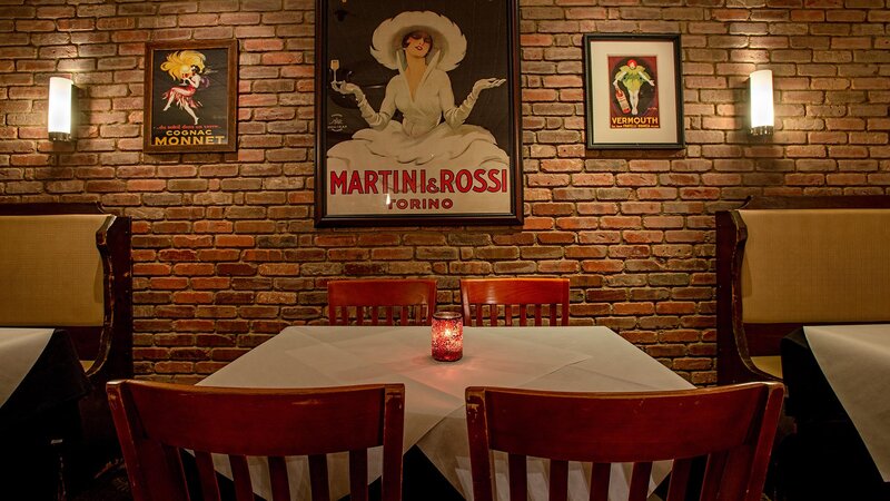 Dining room with table set for four with vintage poster of Martini & Rossi on the wall